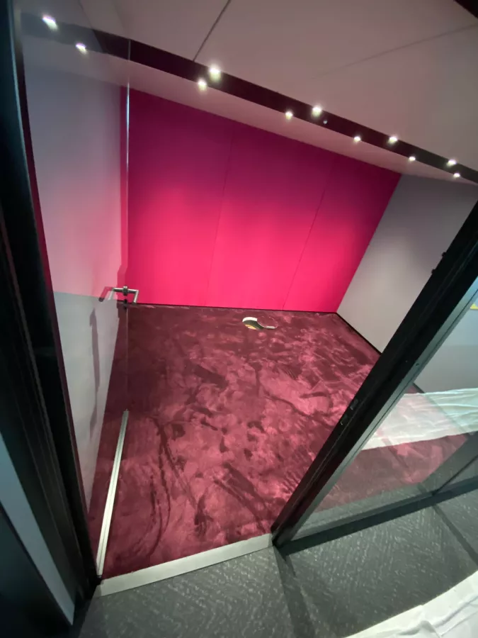 Roter Teppichboden mit pinkfarbener Wand