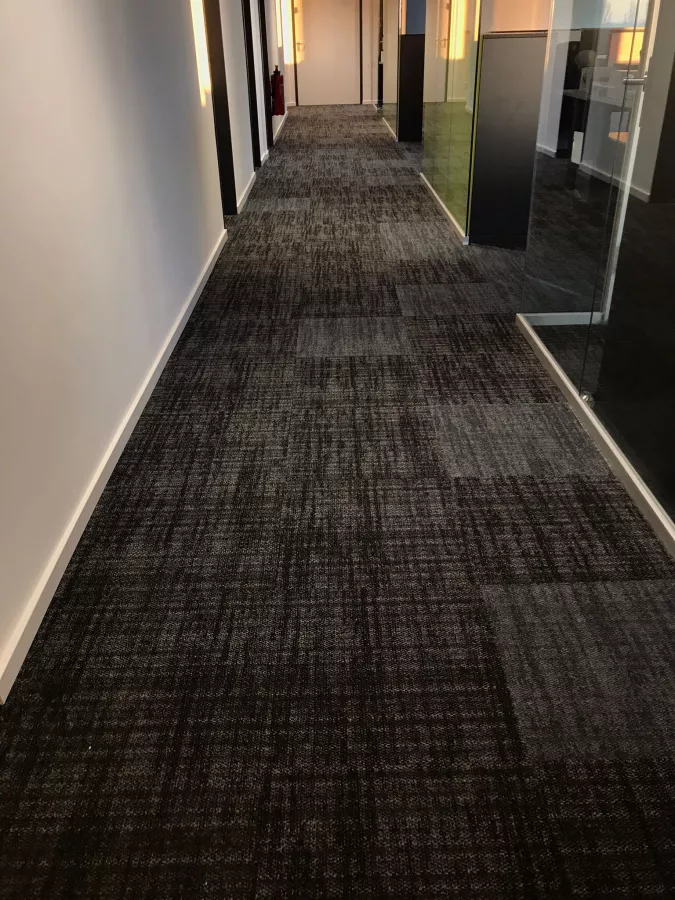 Helle und dunkle Teppichfliesen für ein einzigartiges Muster Im Bürogang